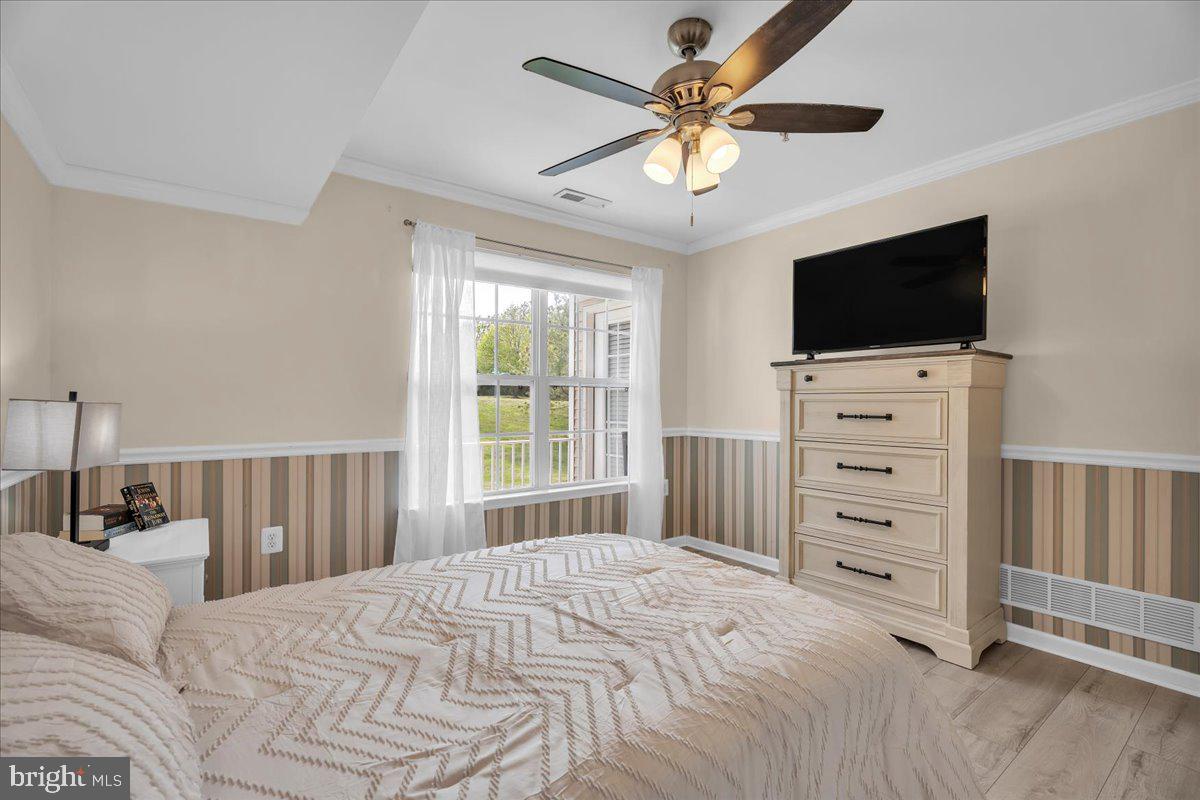 207 Redbud Lane, Unit 207 Mantua, NJ 08051 - Photo 16 of 22 a bedroom with a bed a flat screen tv and a chandelier