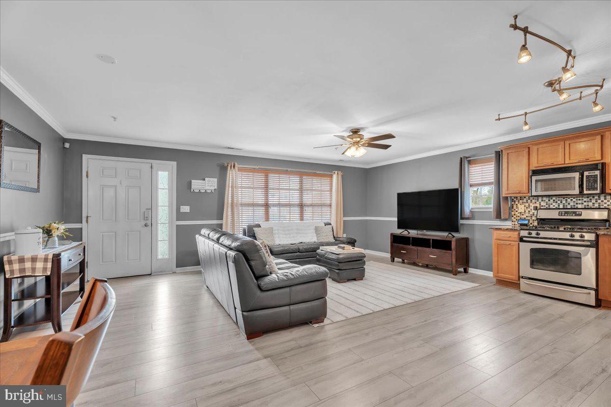 207 Redbud Lane, Unit 207 Mantua, NJ 08051 - Photo 7 of 22 a living room with furniture a flat screen tv and kitchen view
