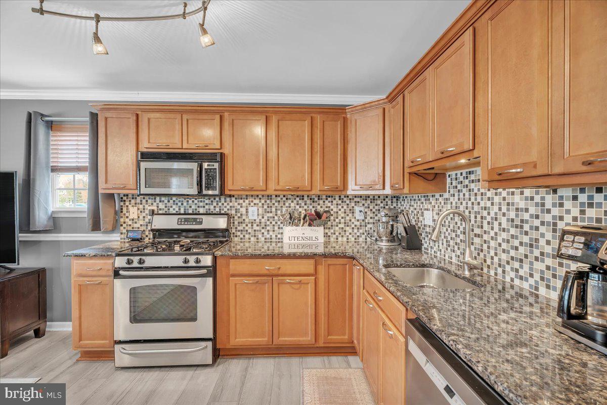 207 Redbud Lane, Unit 207 Mantua, NJ 08051 - Photo 10 of 22 a kitchen with granite countertop a sink stainless steel appliances wooden floor and a window