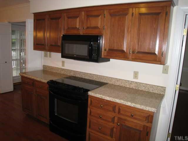 2408 Chello Court Raleigh, NC 27612 - Photo 4 of 10 a kitchen with granite countertop stainless steel appliances wooden cabinets and a wooden floor