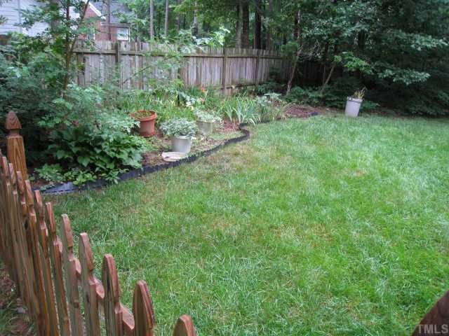 2408 Chello Court Raleigh, NC 27612 - Photo 9 of 10 a view of a backyard with potted plants and wooden fence