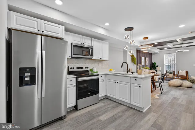 a open kitchen with stainless steel appliances granite countertop a refrigerator stove and sink