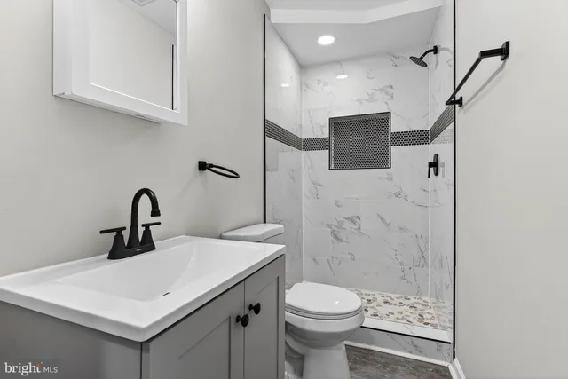 a bathroom with a sink a toilet and shower