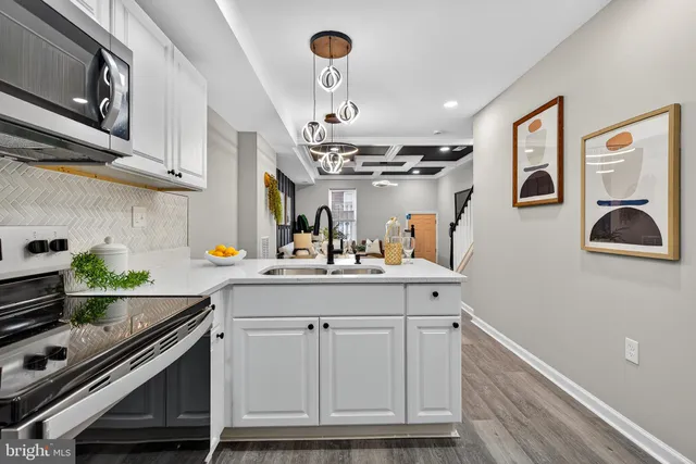 a kitchen with stainless steel appliances a stove a cabinets and a window