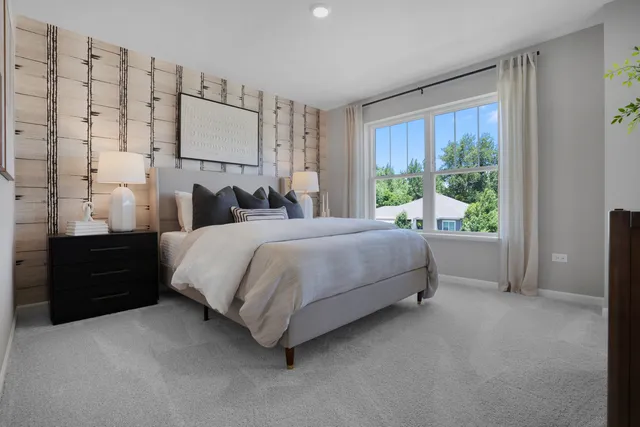 a bedroom with a bed lamp and a large window