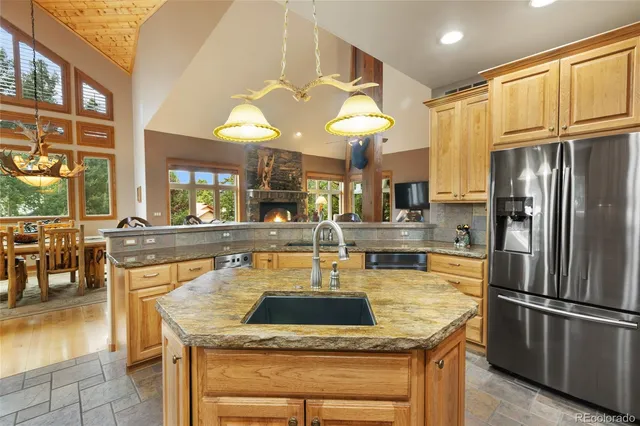 a kitchen with stainless steel appliances granite countertop a sink a stove and a refrigerator