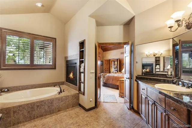 a large spacious bathroom with a tub a double vanity sink a mirror and a shower