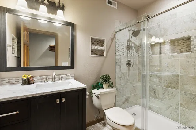 a bathroom with a toilet a sink and glass door