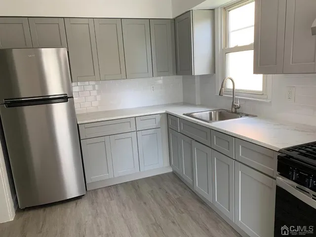 a kitchen with a sink a refrigerator and window