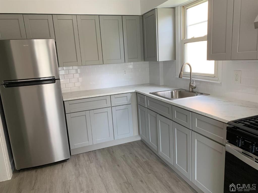 13 Melbourne Court, Unit 1 Woodbridge, NJ 07095 - Photo 11 of 11 a kitchen with a sink a refrigerator and window