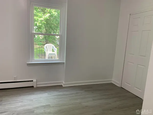 a view of a room with wooden floor and window