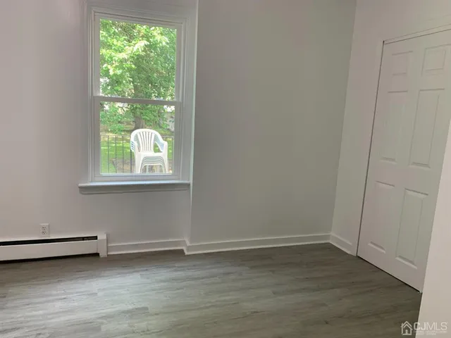 a view of a room with wooden floor and window