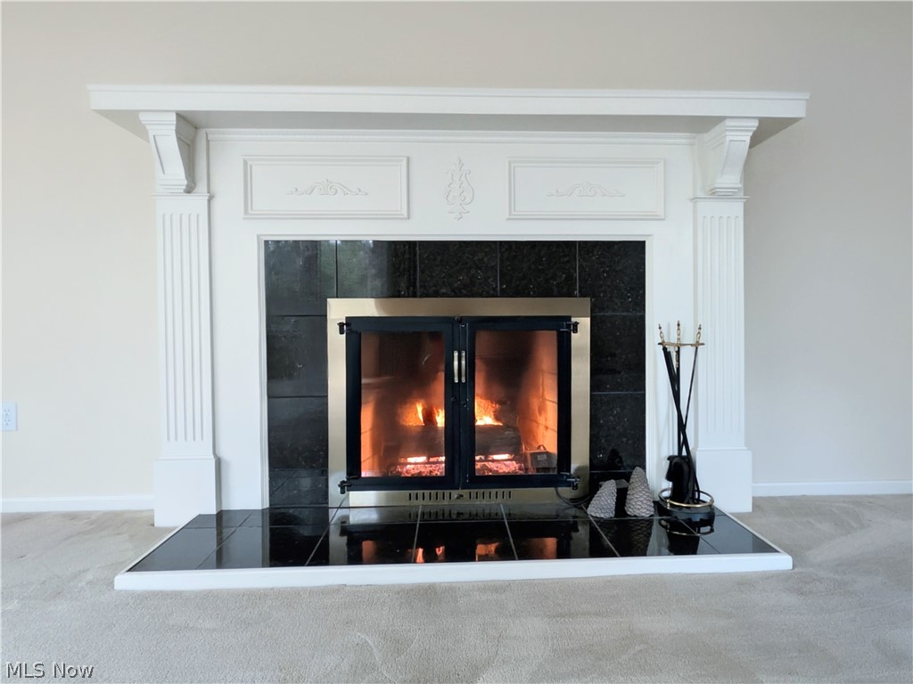 6409 Old Woods Road Ashtabula, OH 44004 - Photo 16 of 43 Fireplace featuring a white mantel, decorative corbels, black tiled surround, brass-framed glass doors, and a tiled hearth