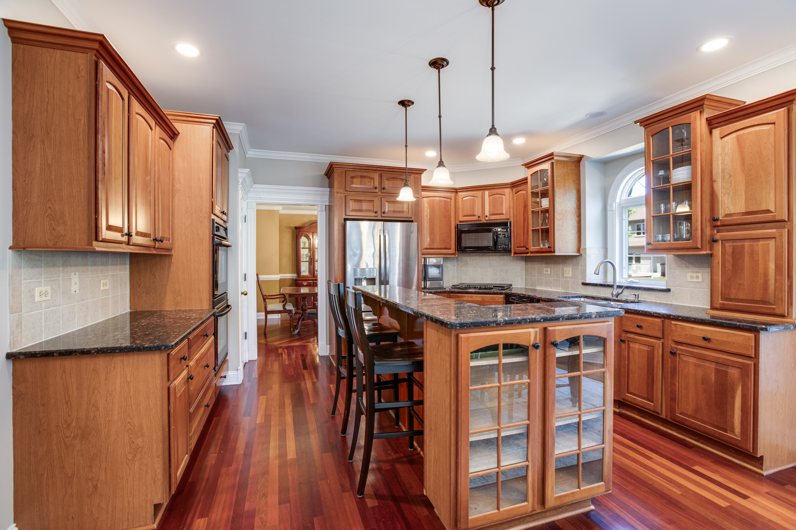 3976 Bluejay Lane Naperville, IL 60564 - Photo 7 of 34 a kitchen with stainless steel appliances granite countertop a stove a sink dishwasher a refrigerator and a dining table with wooden floor