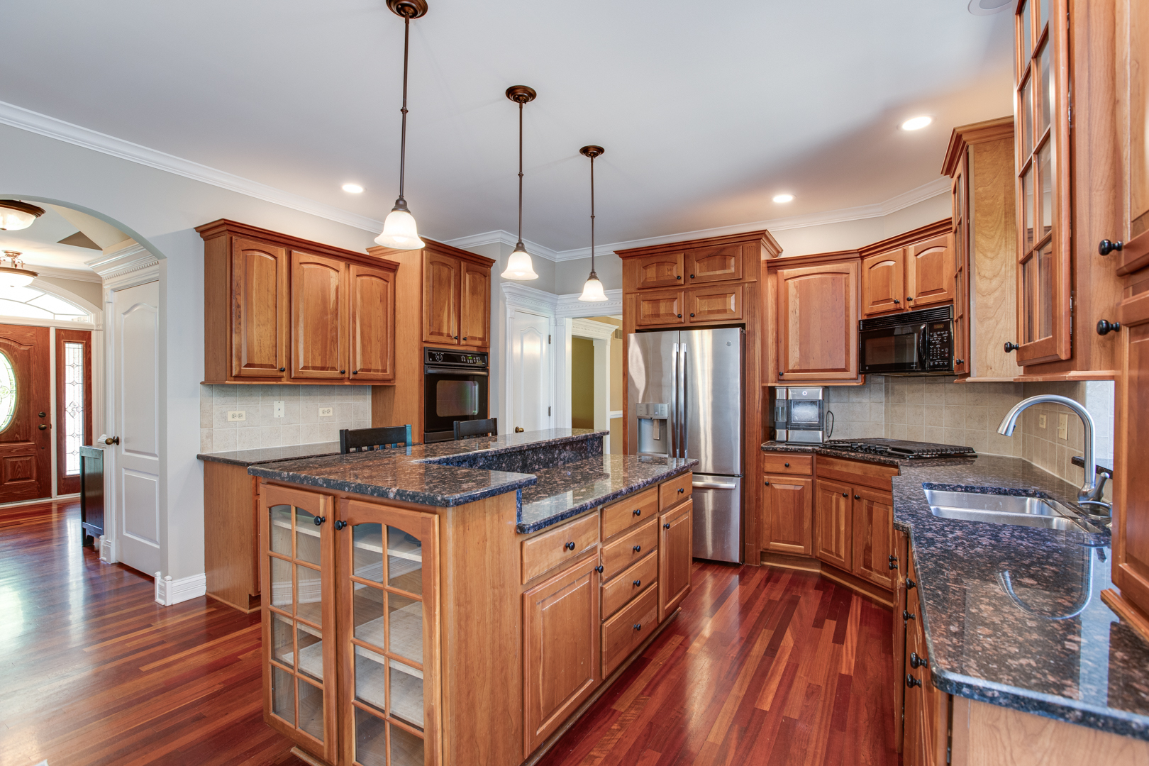 3976 Bluejay Lane Naperville, IL 60564 - Photo 8 of 34 a kitchen with stainless steel appliances granite countertop wooden cabinets a refrigerator a sink a stove a microwave and wooden floors