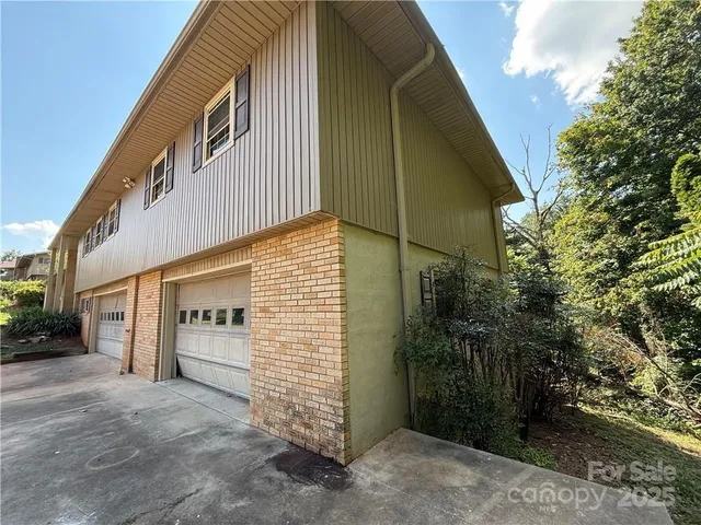 a front view of a house with plants and garage
