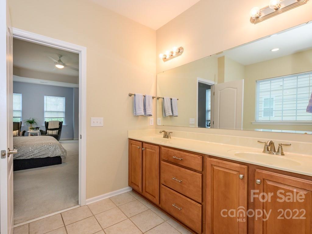 8421 Cotton Press Road Charlotte, NC 28277 - Photo 34 of 40 a en suite bathroom with a sink a mirror and a shower