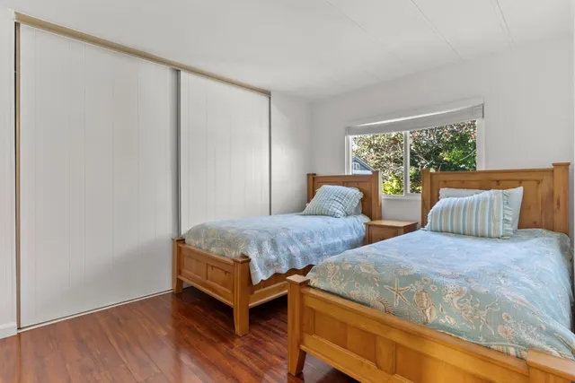 a bedroom with two beds and window