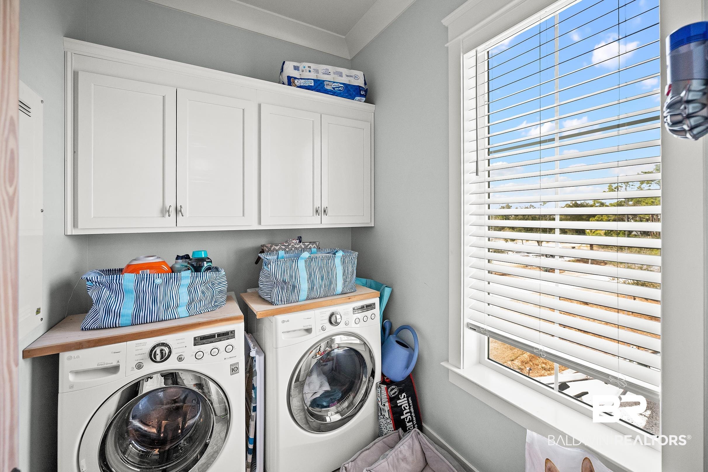 33186 Marlin Key Drive Orange Beach, AL 36561 - Photo 82 of 87 Laundry room featuring plenty of natural light, cabinet space, and washer and dryer
