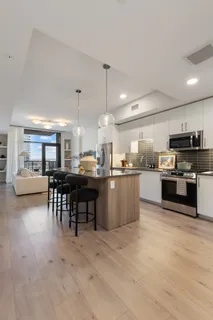 a kitchen with stainless steel appliances kitchen island granite countertop a table and chairs in it