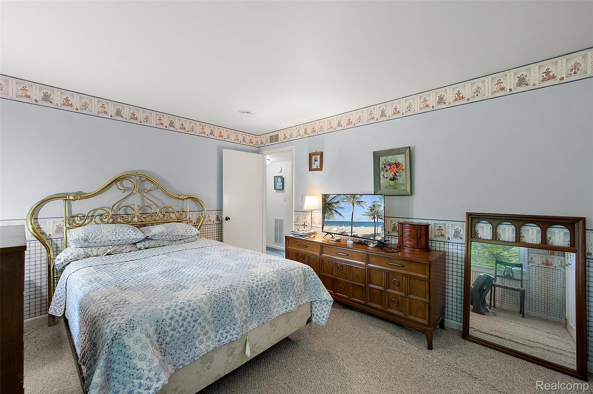 930 Little Hill Court Rochester, MI 48307 - Photo 31 of 38 Room featuring light blue walls with decorative wallpaper borders, a brass-tone metal bed frame, wood-finish dresser, and carpeted flooring