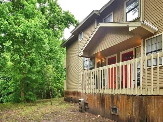 a view of a house with a small yard and wooden fence