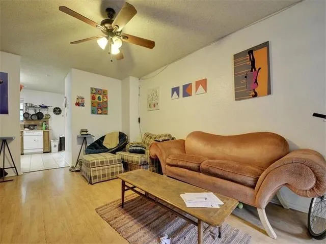 a living room with furniture a ceiling fan and a rug