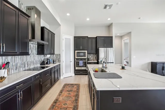 a kitchen with stainless steel appliances granite countertop a refrigerator and a stove top oven
