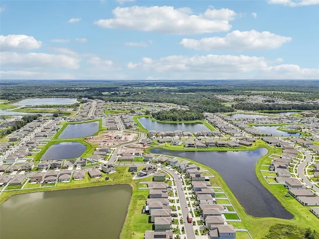 a front view of house with yard and trees around