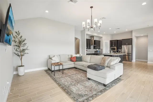 a living room with furniture and a chandelier