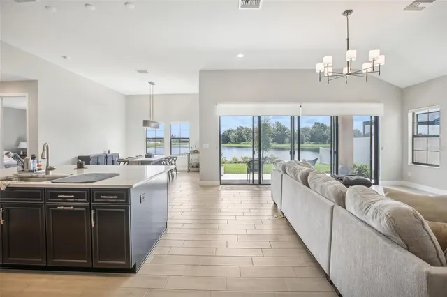 a large white kitchen with wooden floor and a sink