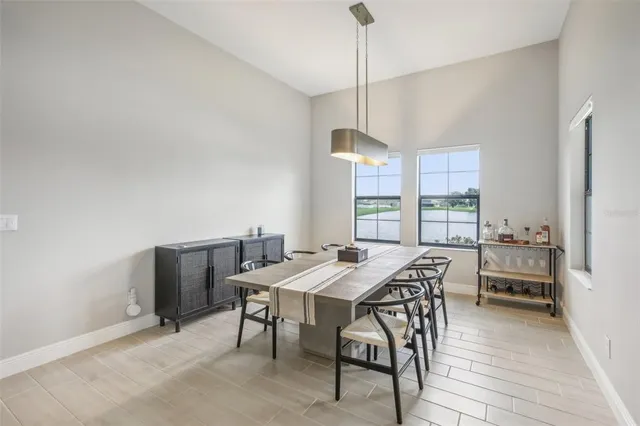 a view of a dining room and livingroom with furniture wooden floor a chandelier