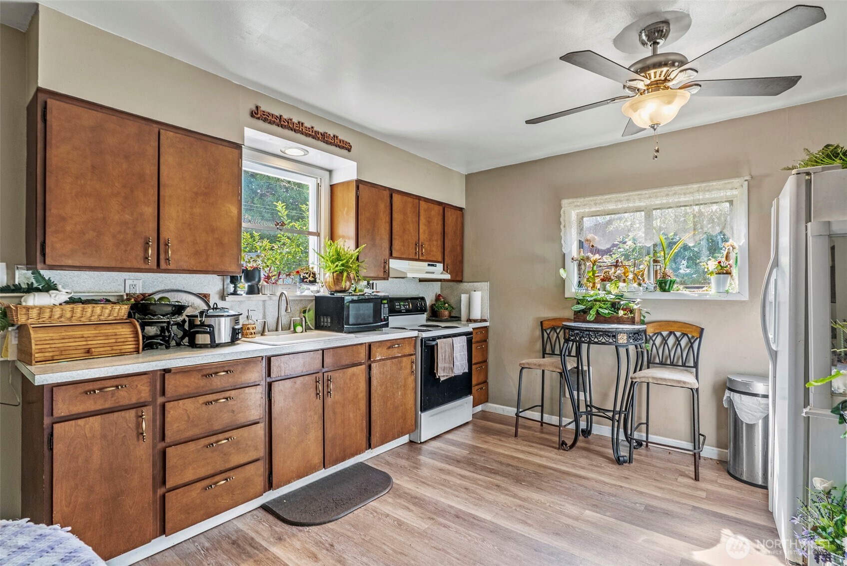 110 Madison Street Ryderwood, WA 98581 - Photo 11 of 30 a kitchen with granite countertop a stove a sink a dining table and chairs with wooden floor