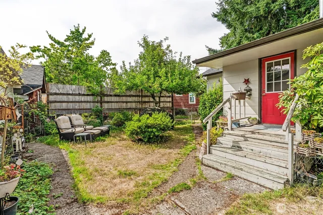 a view of a chair and table in backyard of the house