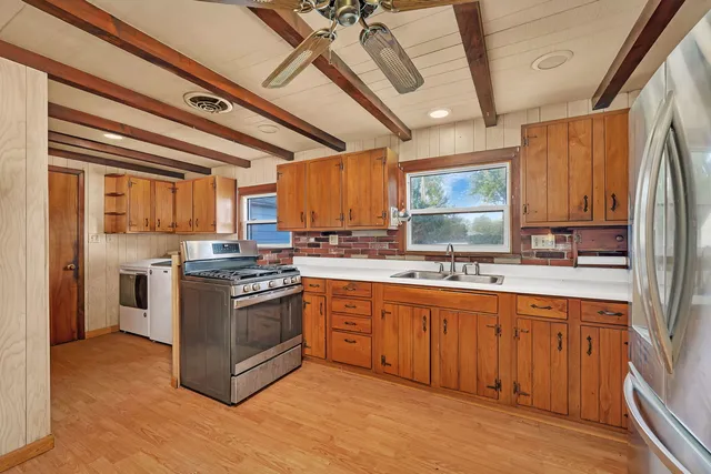 a kitchen with stainless steel appliances granite countertop a stove a sink dishwasher and a refrigerator