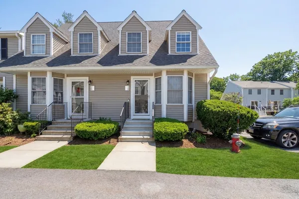 a front view of a house with a garden and plants