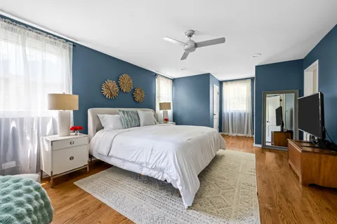 a bedroom with bed and a flat tv screen on dresser