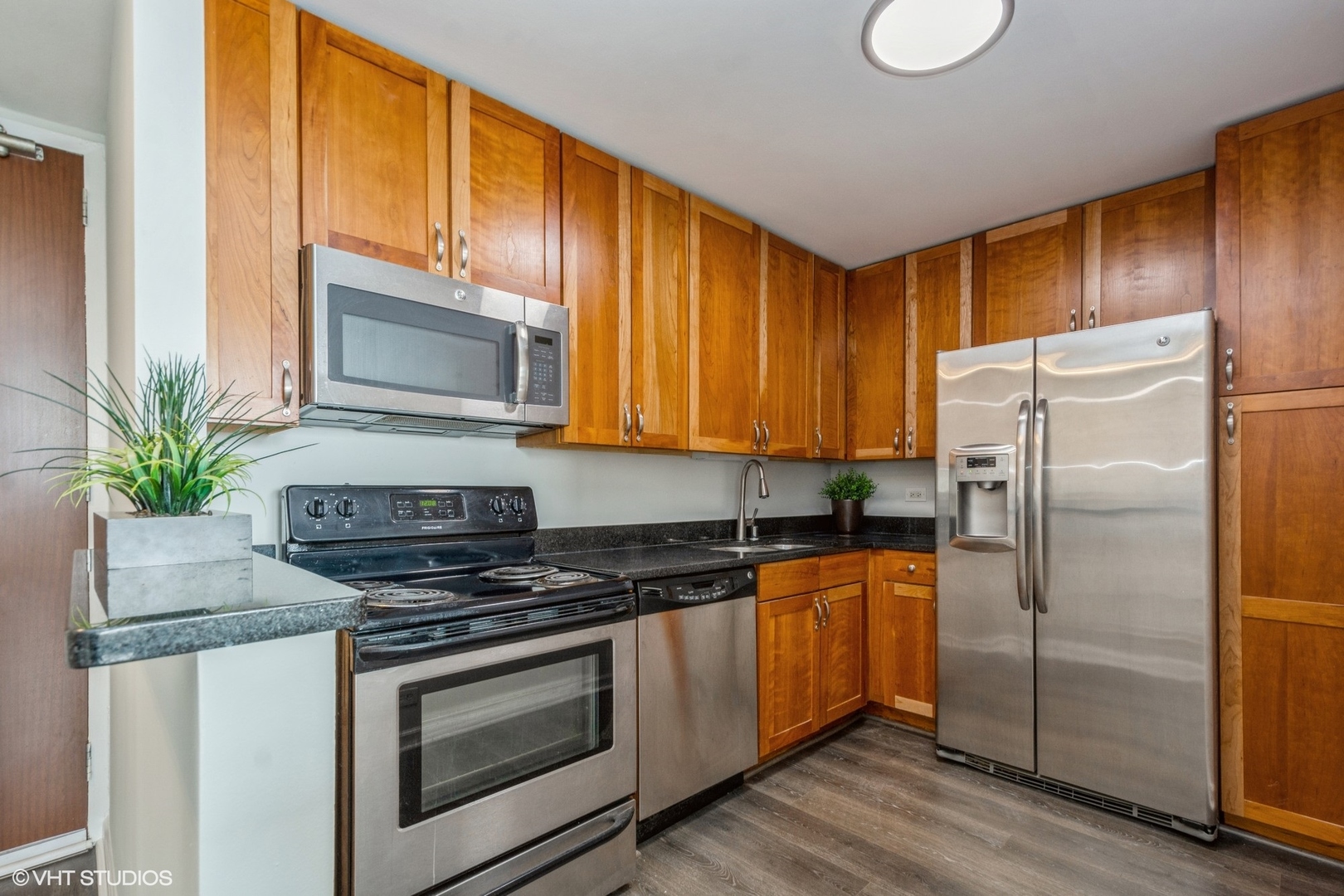 655 West Irving Park Road, Unit 5511 Chicago, IL 60613 - Photo 2 of 29 a kitchen with granite countertop a refrigerator stove and microwave