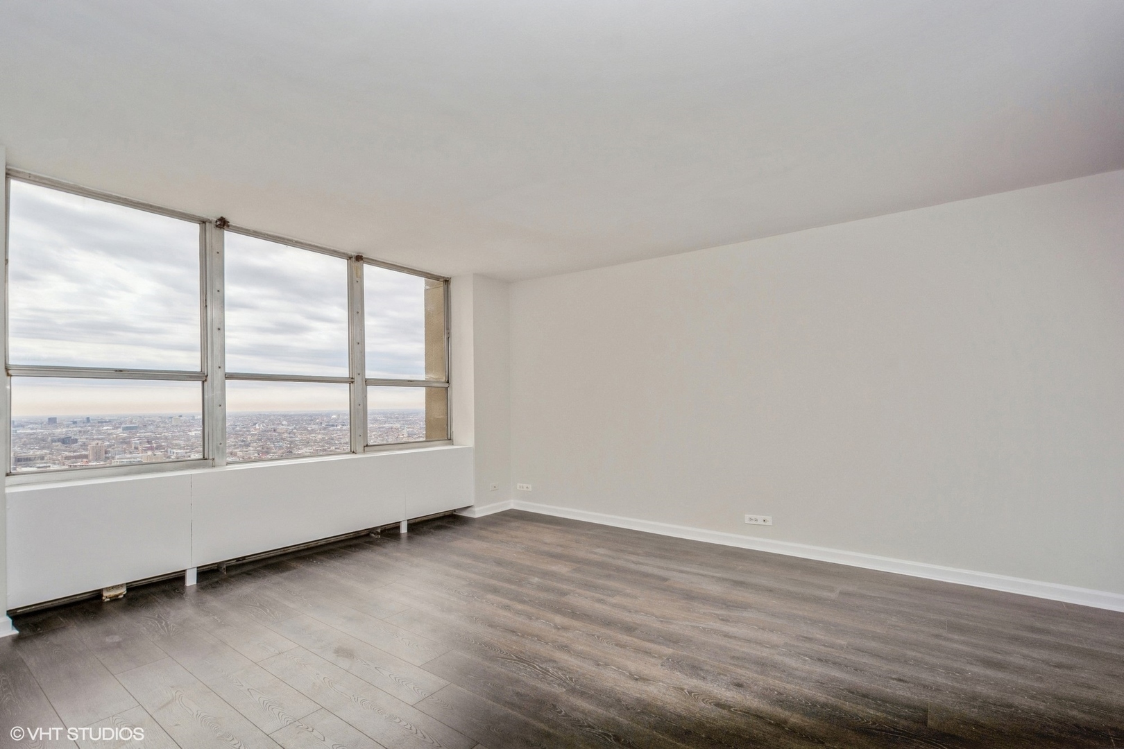 655 West Irving Park Road, Unit 5511 Chicago, IL 60613 - Photo 8 of 29 an empty room with wooden floor and windows