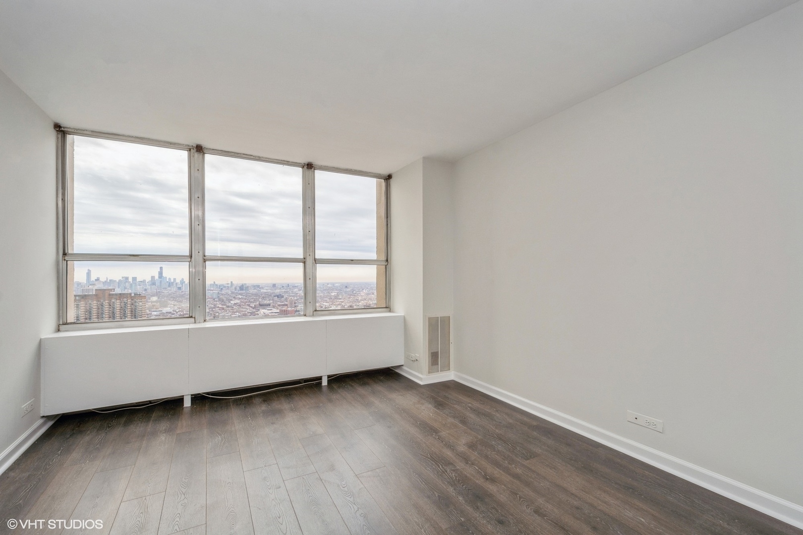 655 West Irving Park Road, Unit 5511 Chicago, IL 60613 - Photo 9 of 29 an empty room with wooden floor and windows