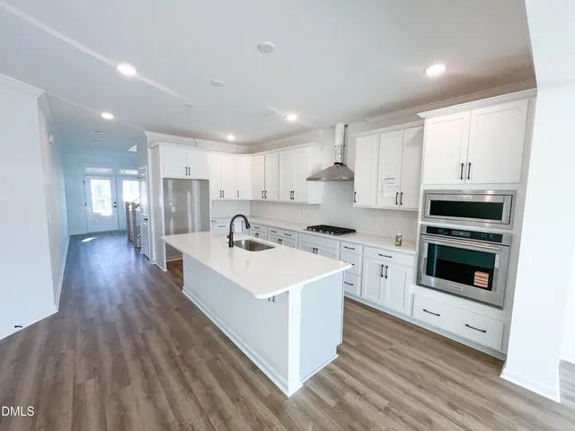 a view of a room with wooden floor and a book shelf