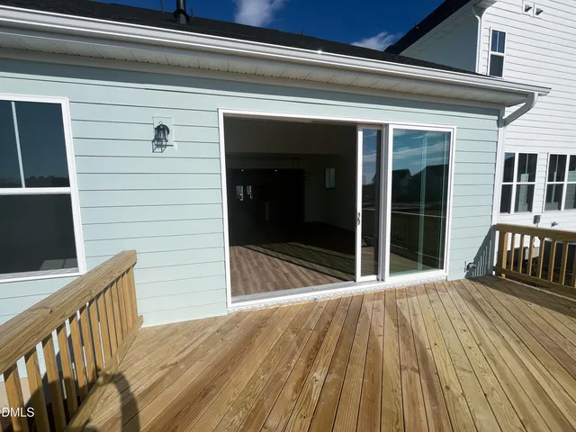 a view of empty room with wooden floor and fireplace