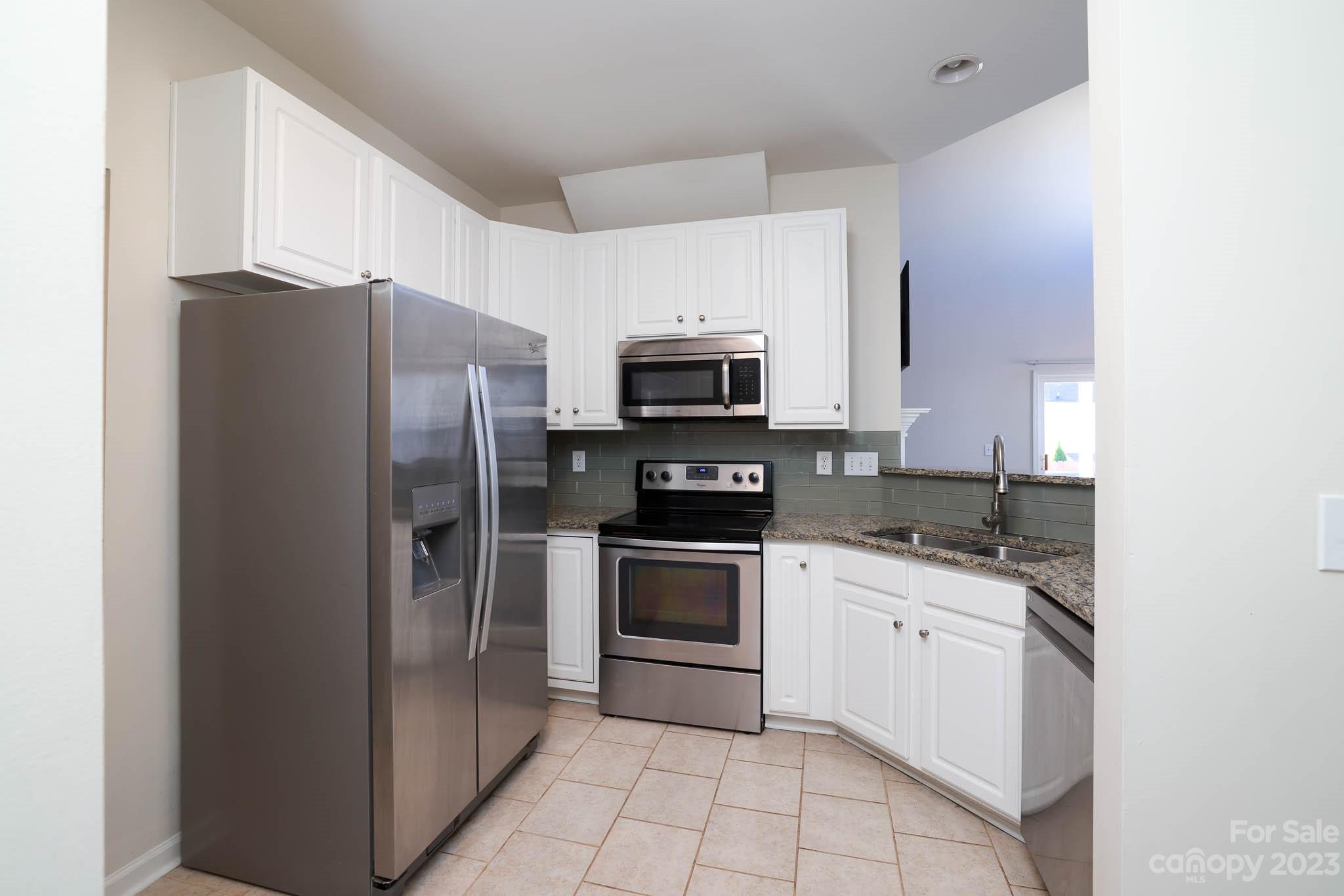 2921 Sedona Place Fort Mill, SC 29708 - Photo 8 of 31 a kitchen with stainless steel appliances granite countertop a refrigerator stove a sink and a microwave