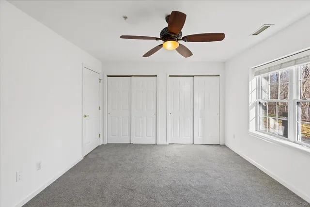 a view of a livingroom with a ceiling fan and window