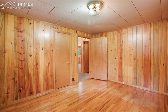 4980 Dodd Road Cascade, CO 80809 - Photo 34 of 48 2nd bedroom featuring light hardwood floors and wood walls