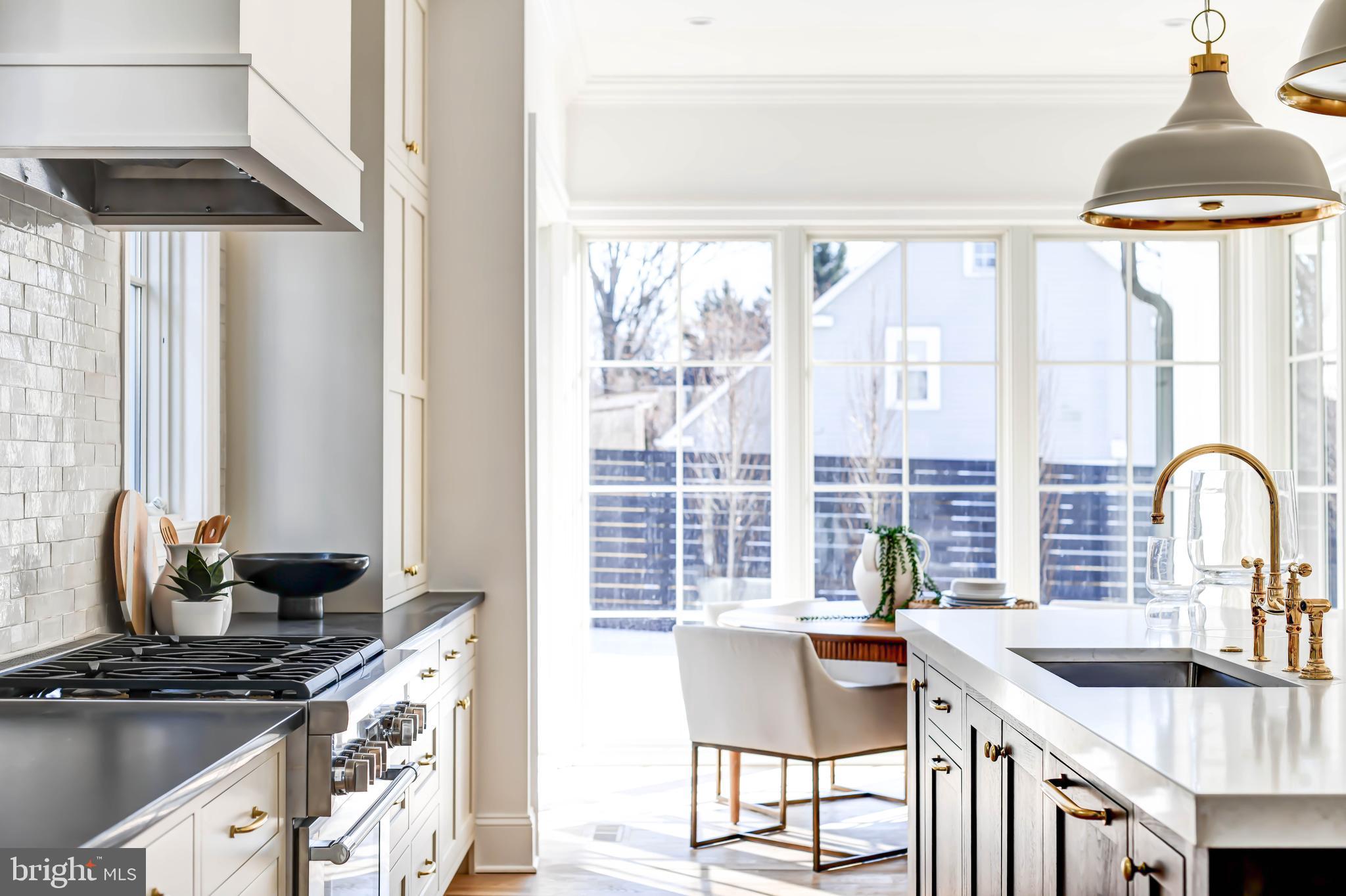 4422 Walsh Street Chevy Chase, MD 20815 - Photo 17 of 93 a kitchen with stainless steel appliances a sink a stove and a dining table with wooden floor