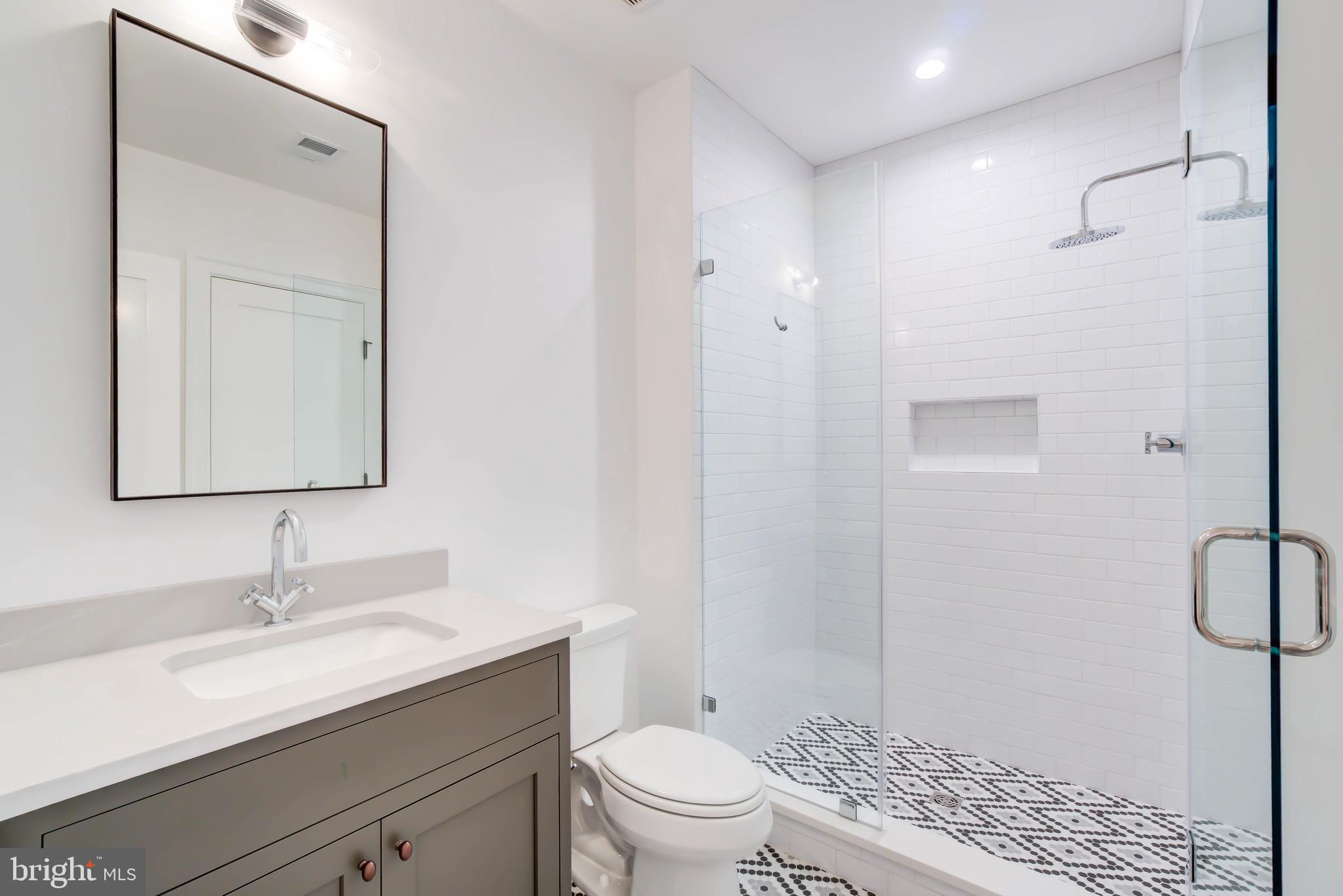 4422 Walsh Street Chevy Chase, MD 20815 - Photo 80 of 93 a bathroom with a granite countertop sink a toilet and a mirror