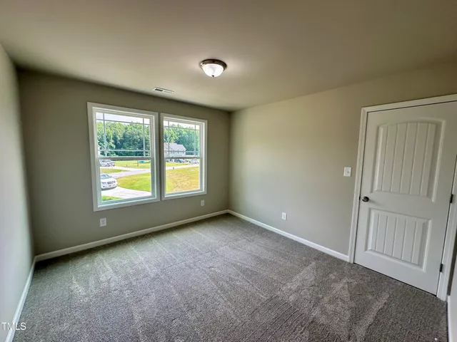 an empty room with windows and closet