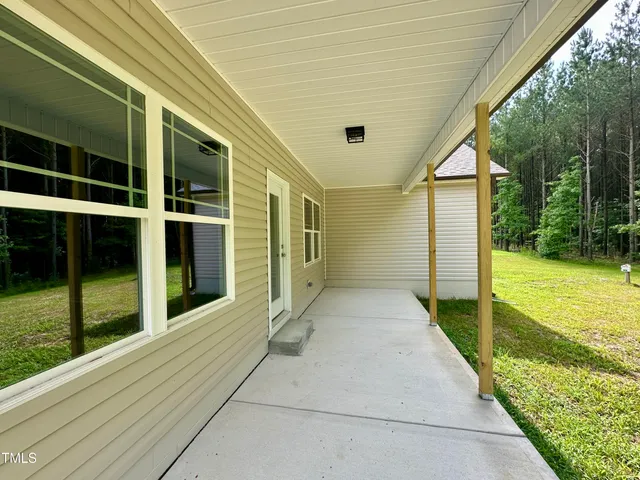 a view of a porch with furniture and garden