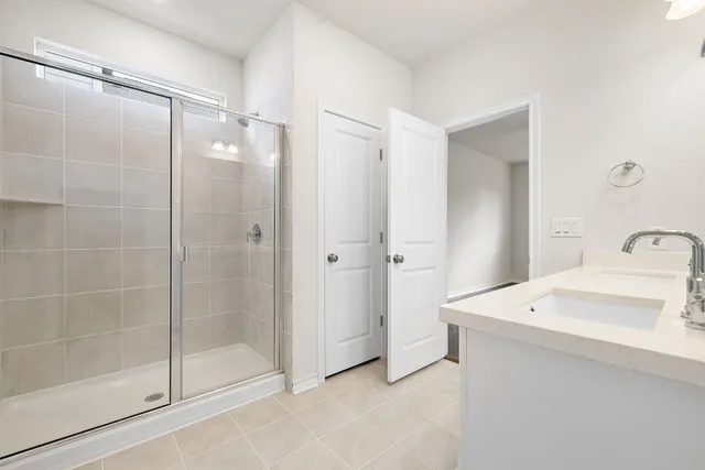 a bathroom with a shower a sink and mirror